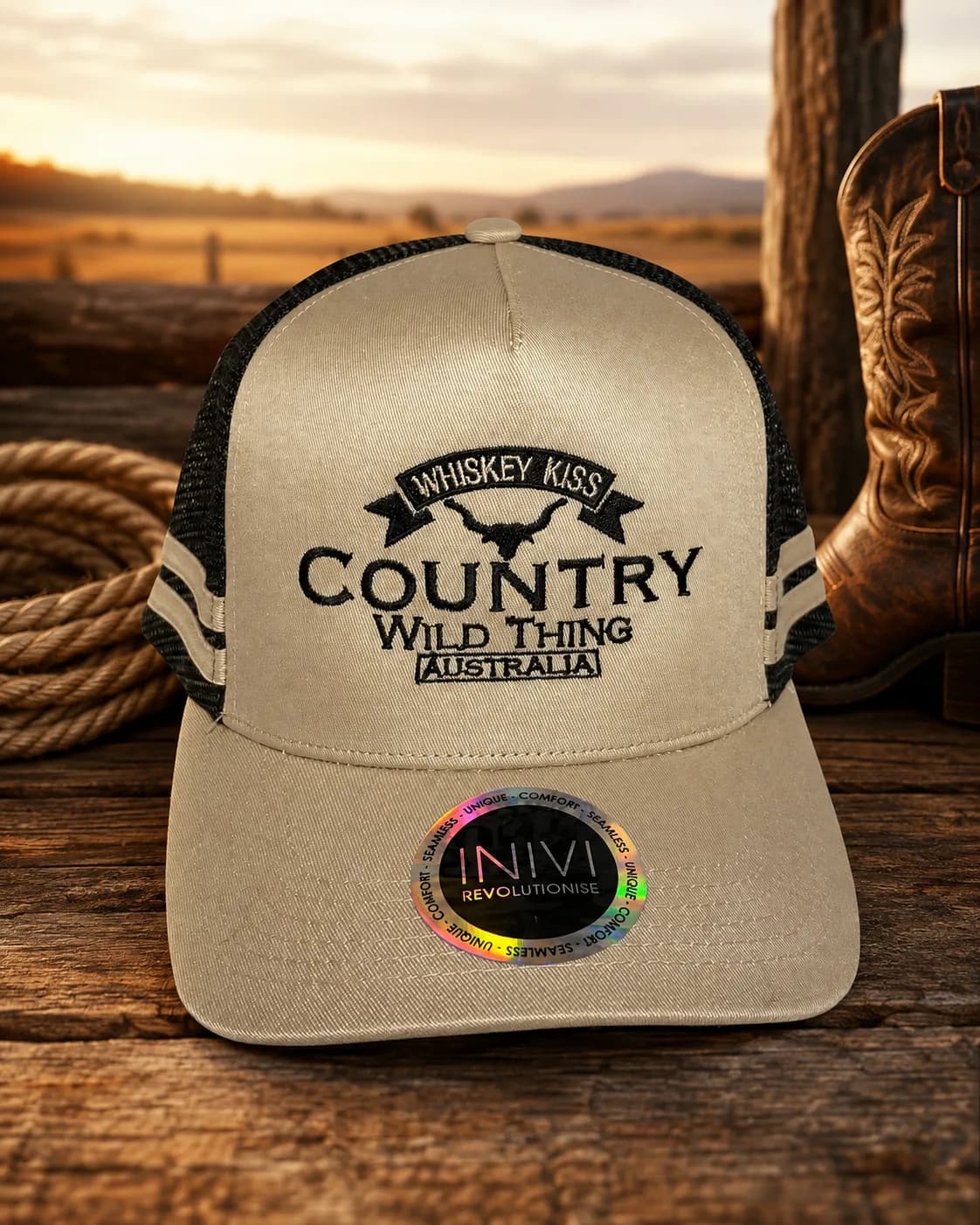 The beige Country Wild Thing trucker cap on a timber table at sunset